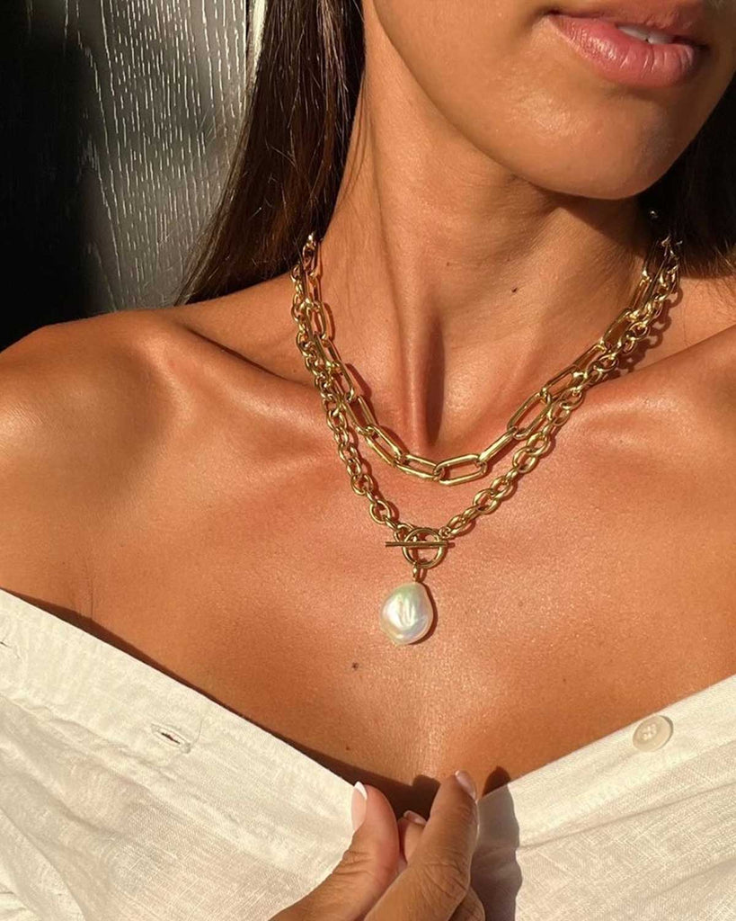 sunlight on neckline of model wearing necklaces 