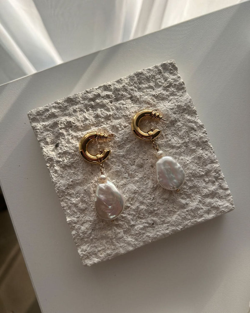 baroque pearl earrings on stone piedestal