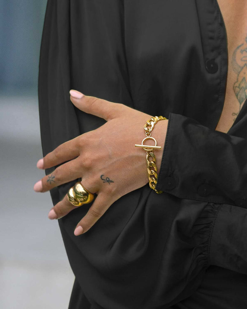 chunky chain bracelet and gold rings with black sateen blouse