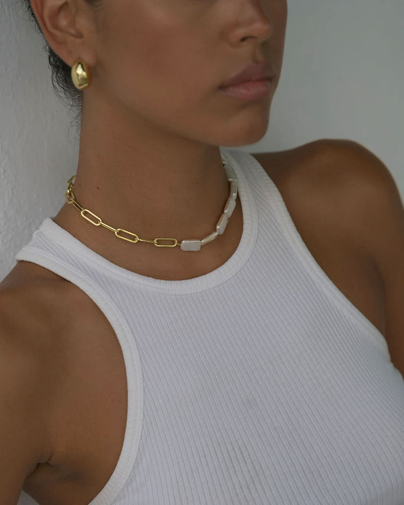 close up on half pearl half chain choker and chunky gold earrings styled with tank top