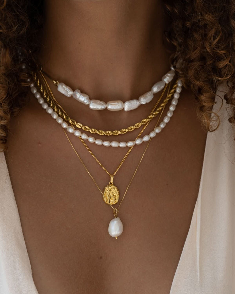 Model wearing layer pearl necklaces