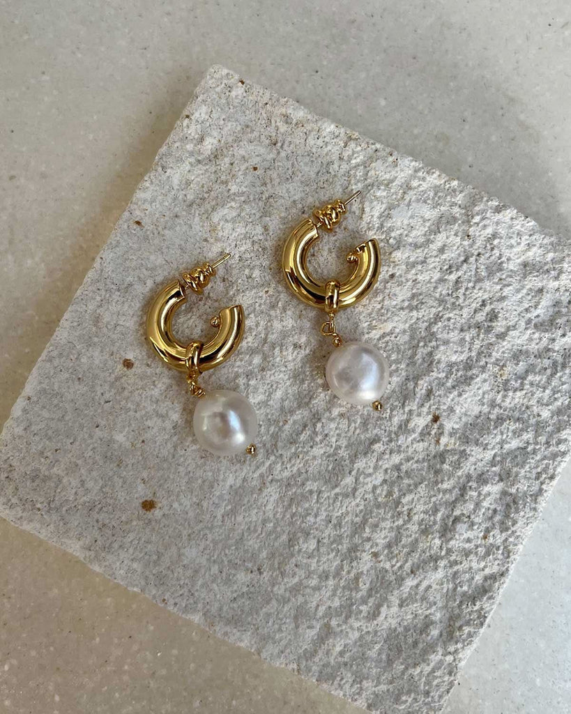 pearl drop earrings on a stone display