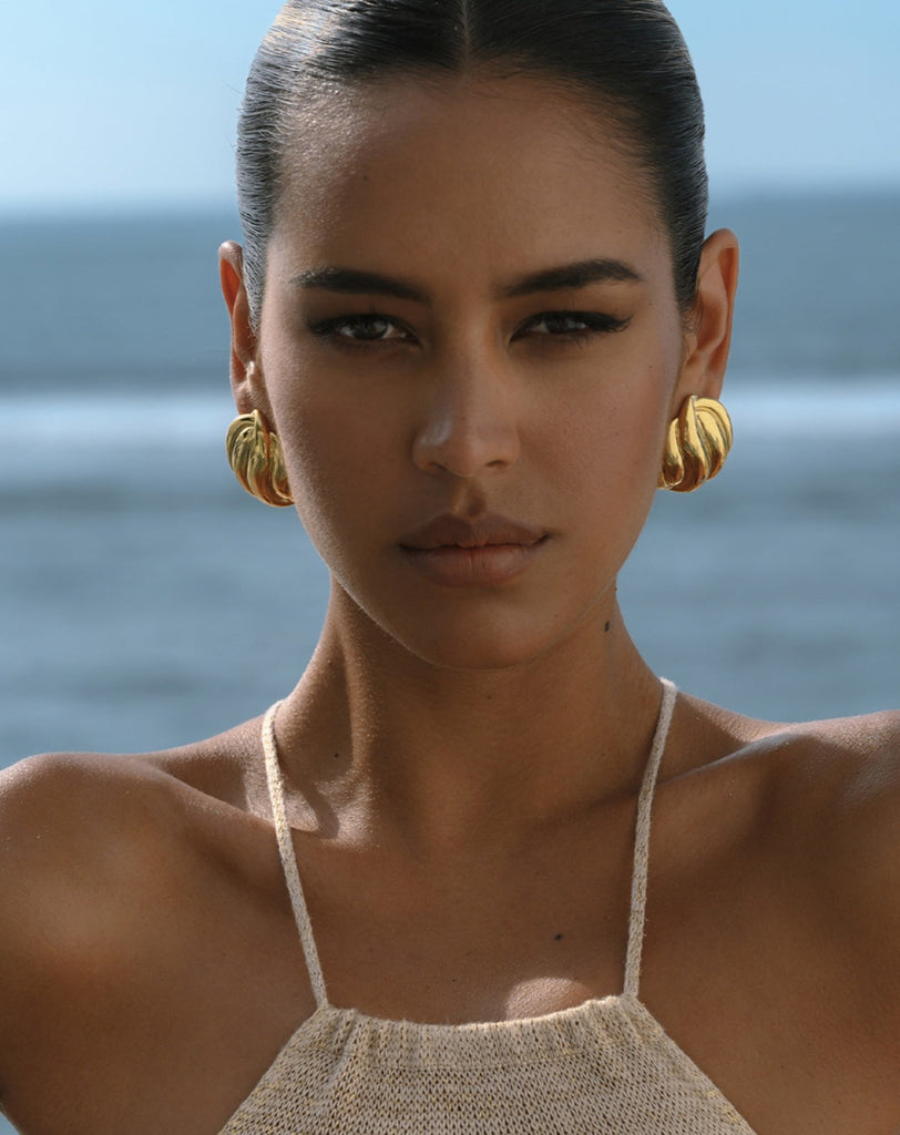 big gold earrings on a model