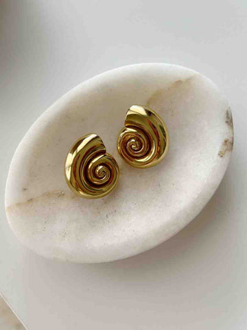gold shell earrings on a marble tray