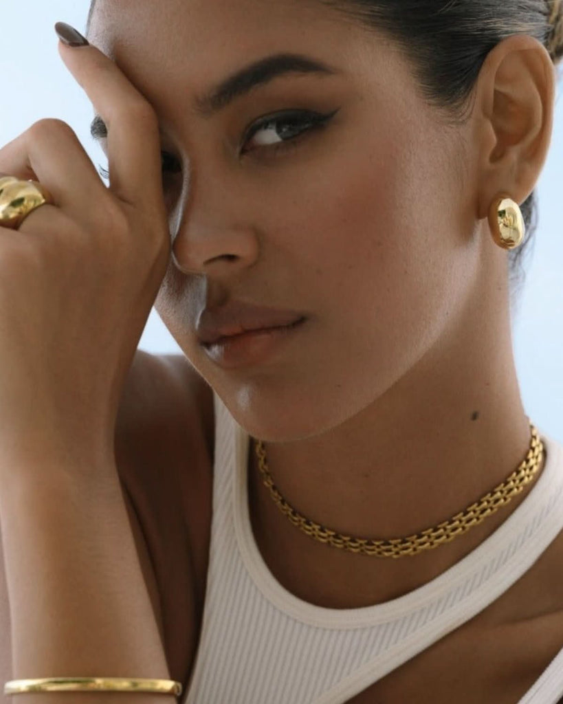 model wearing chunky gold jewelry