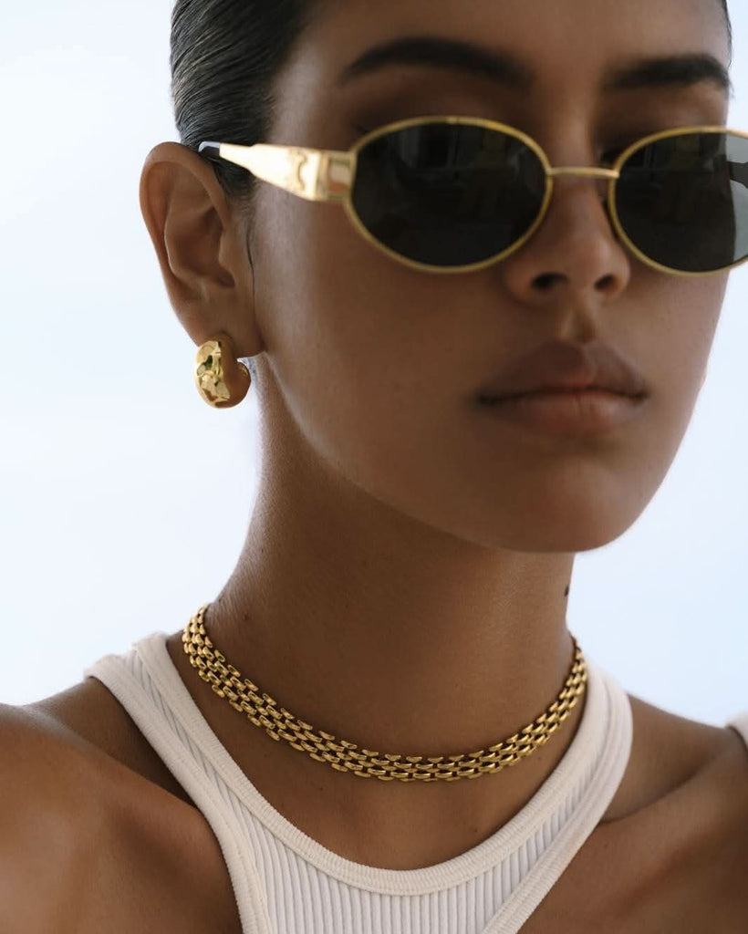 model wearing a chunky choker gold necklace