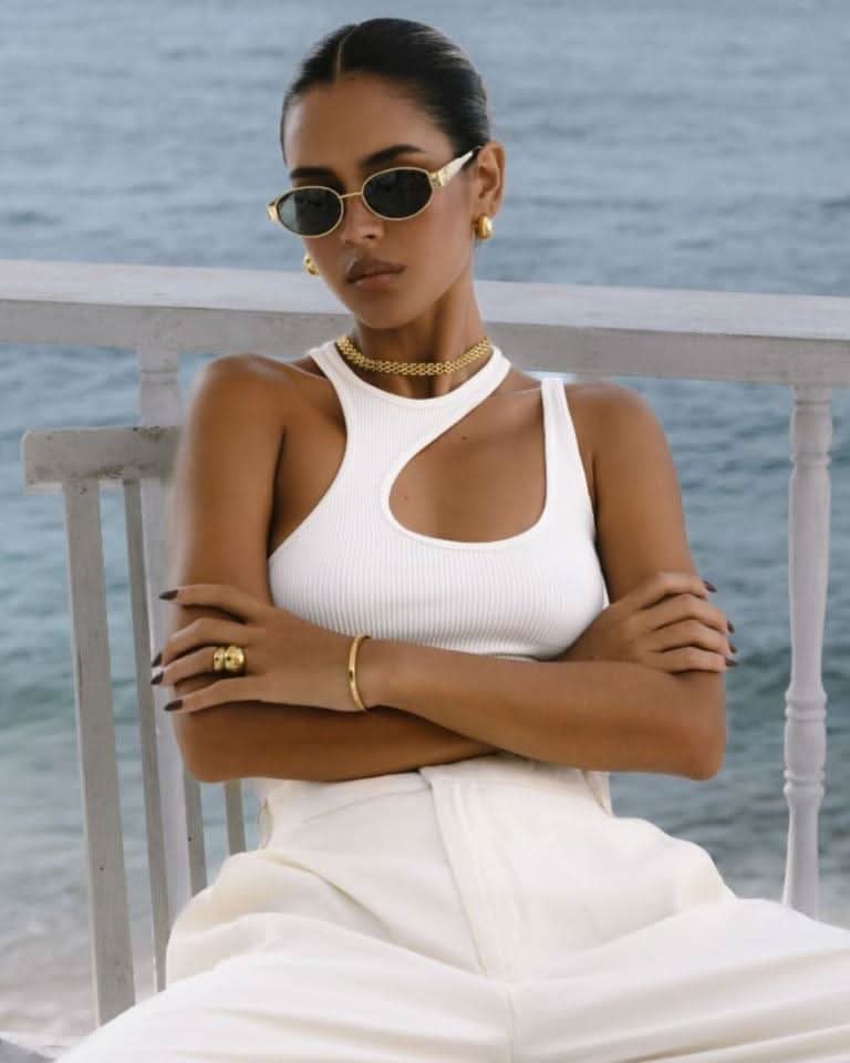 Model in chair wearing a gold choker necklace