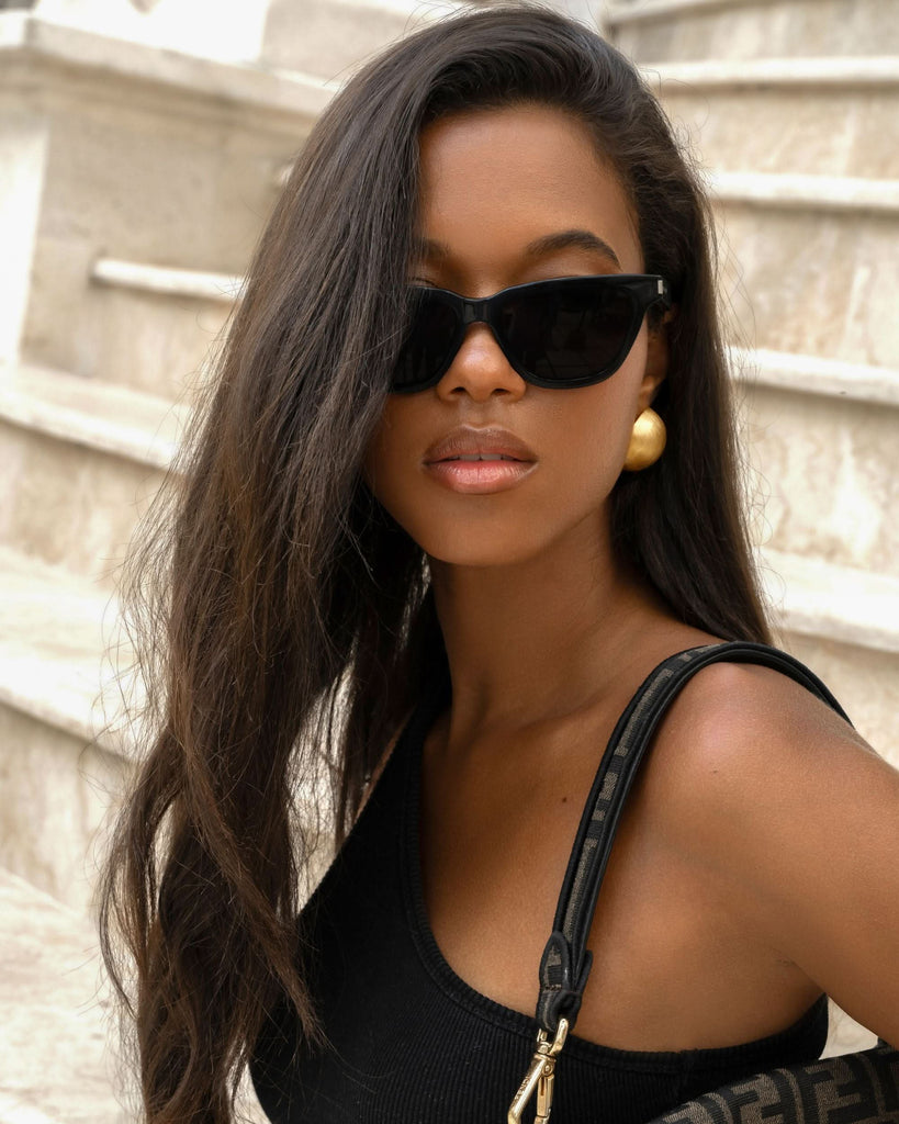 sunglasses styled with large gold stud earrings