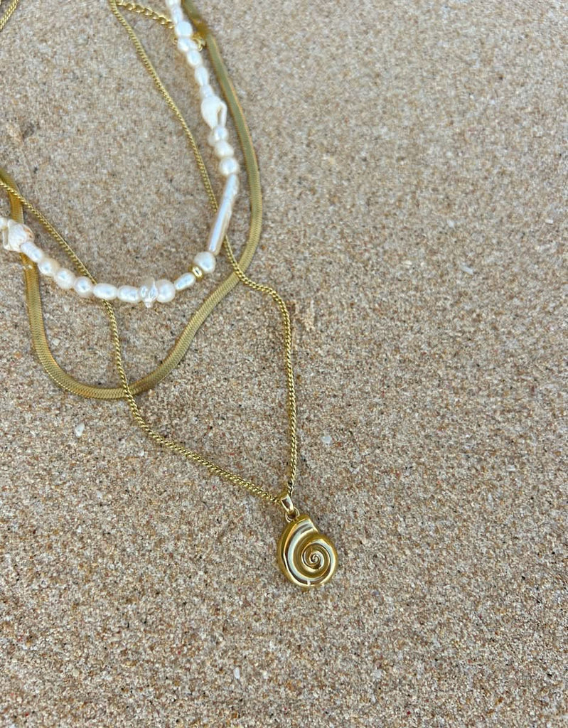 cult of sun  shell pendant necklace layered at the beach