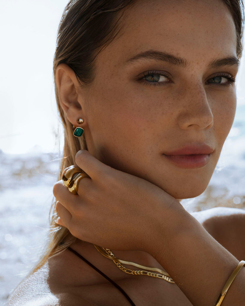 malachite barbell earrings styled with gold jewelry