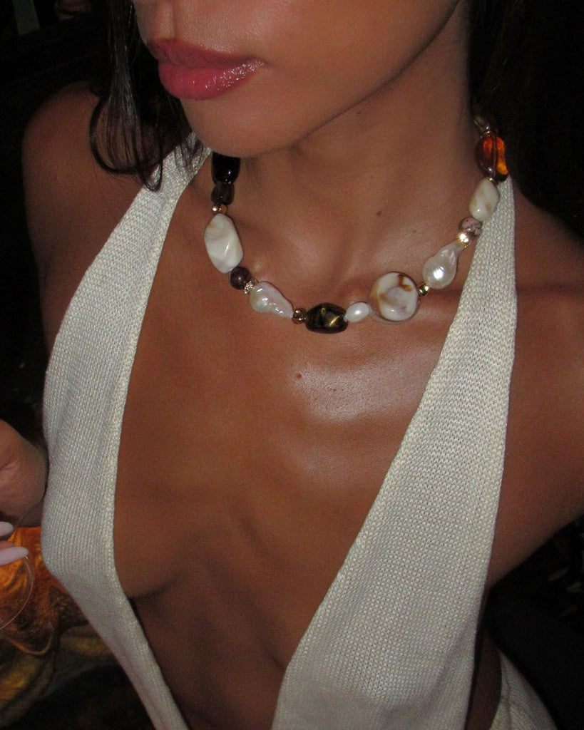 Close-up of a large bead necklace with pearls and beads on a person