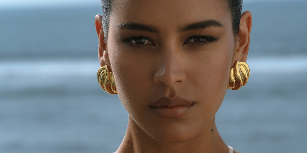 Bri gold statement earrings on a model