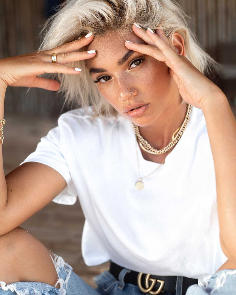 blond short hair model sitting down wearing casual stylish outfit 