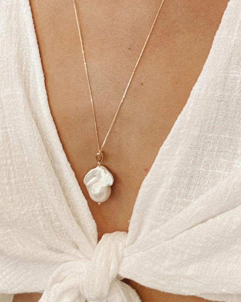 large baroque pearl necklace on dainty gold chain close up