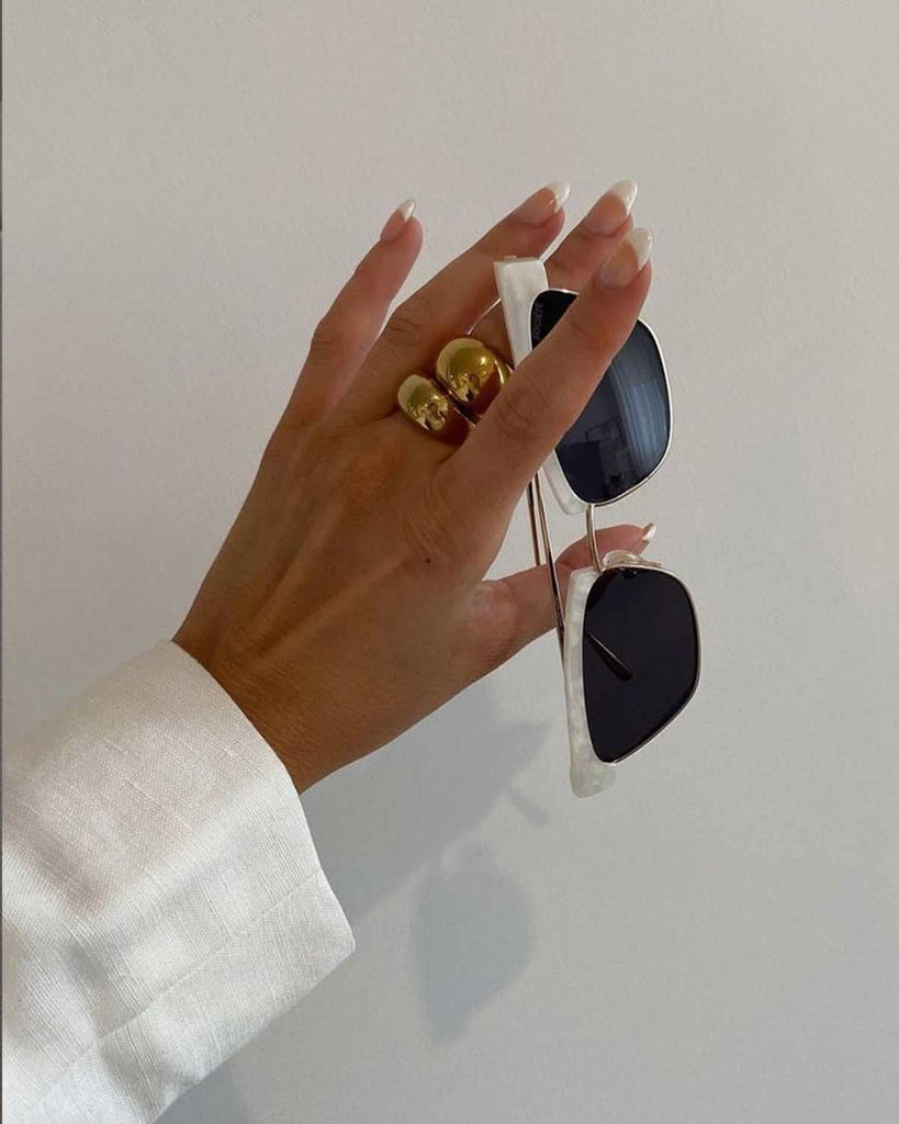 hand holding sunnies wearing two stackable rings 