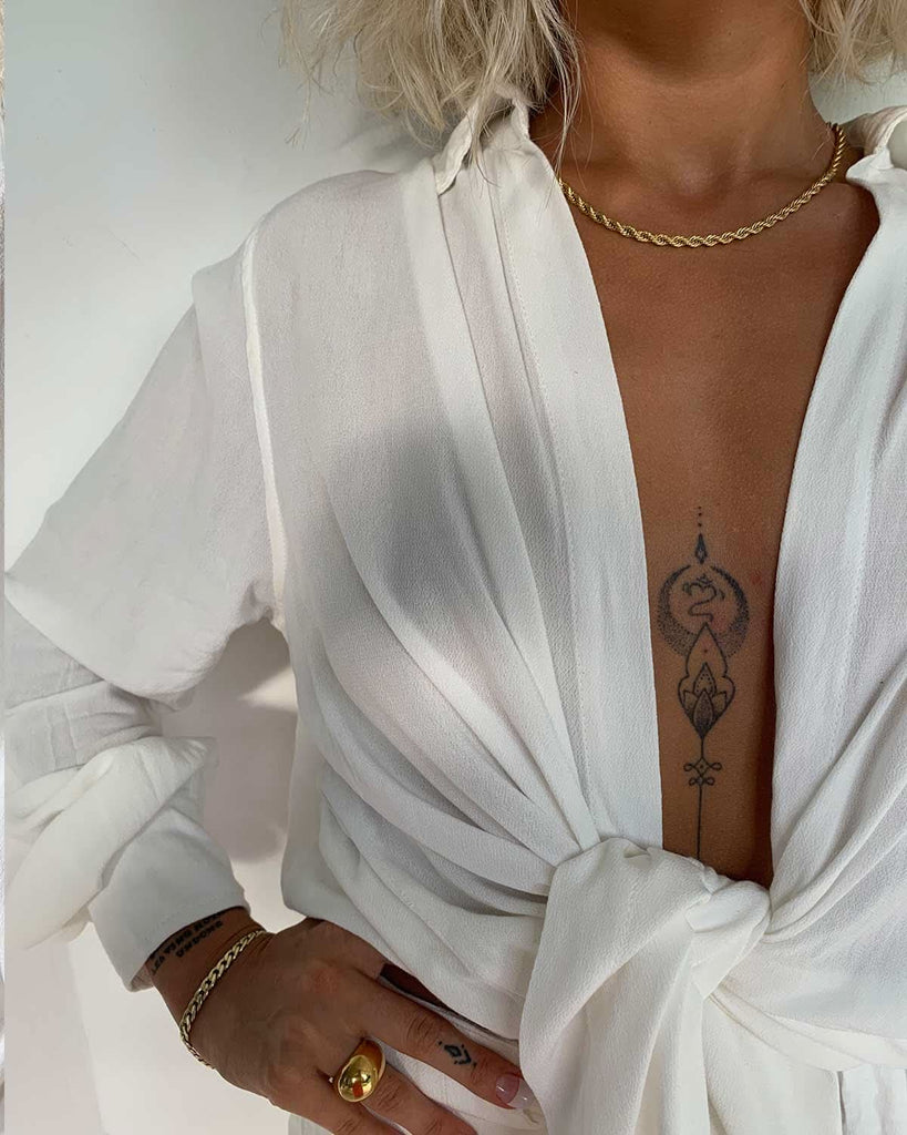 large cleavage white linen top and gold jewelry  