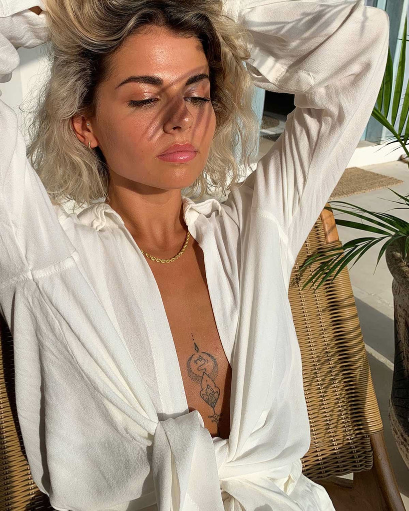 model wearing casual white top and gold chain