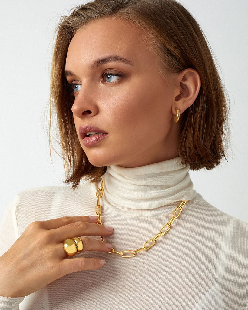 close up of model wearing jewelry with white outfit 
