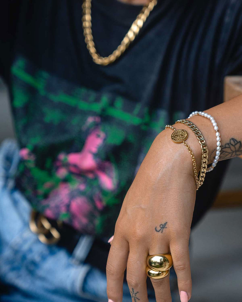 gold and pearl bracelets, gold rings, and chunky gold chain necklace 