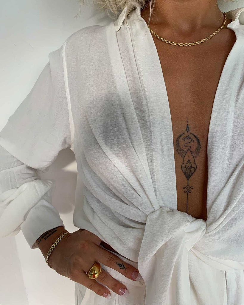 Woman in white robe wearing a gold bracelet