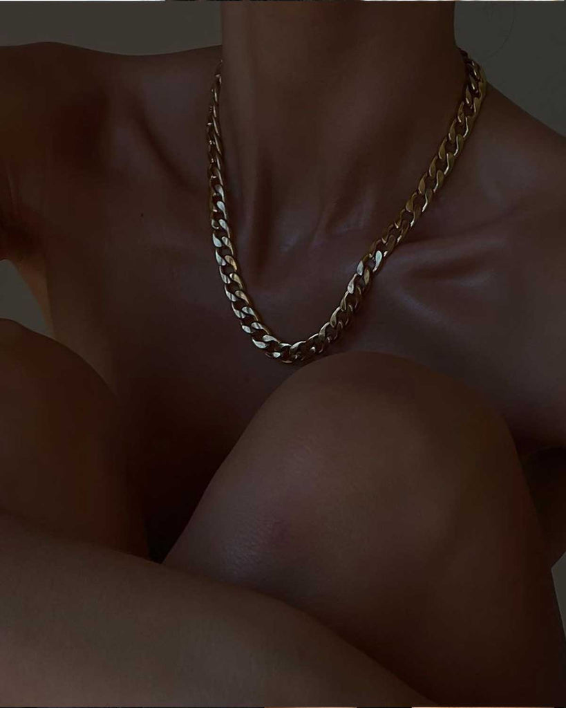 naked woman wearing golden Cuban necklace 