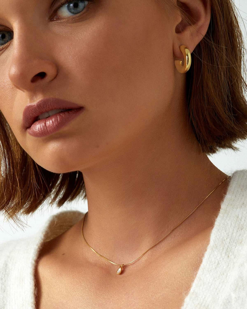 small chunky gold earrings styled with delicate gold necklace 