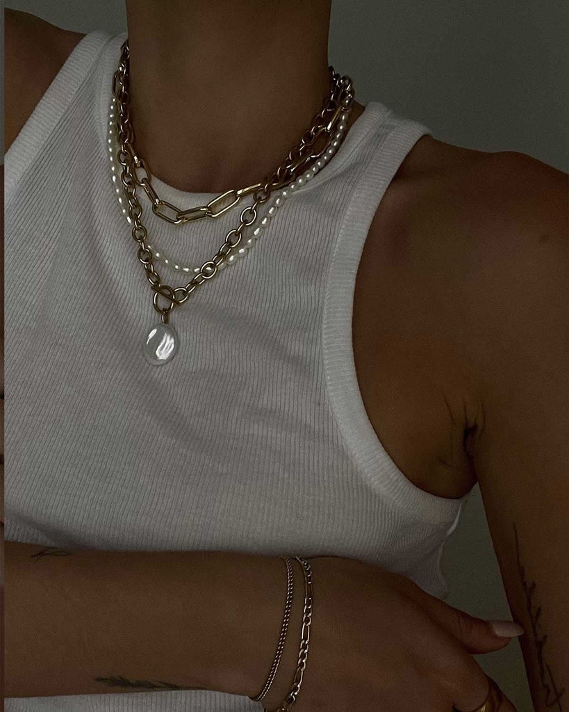 white tank top styled with three layers of necklaces 