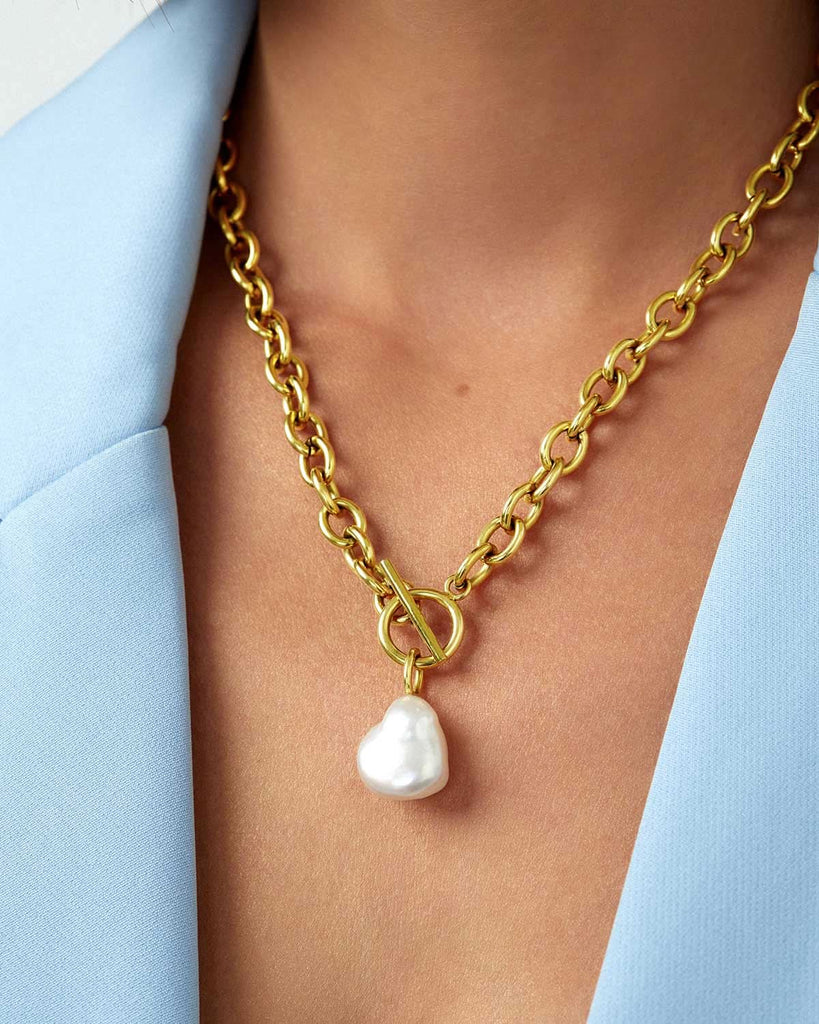 close up baby blue blazer and chunky gold and pearl necklace
