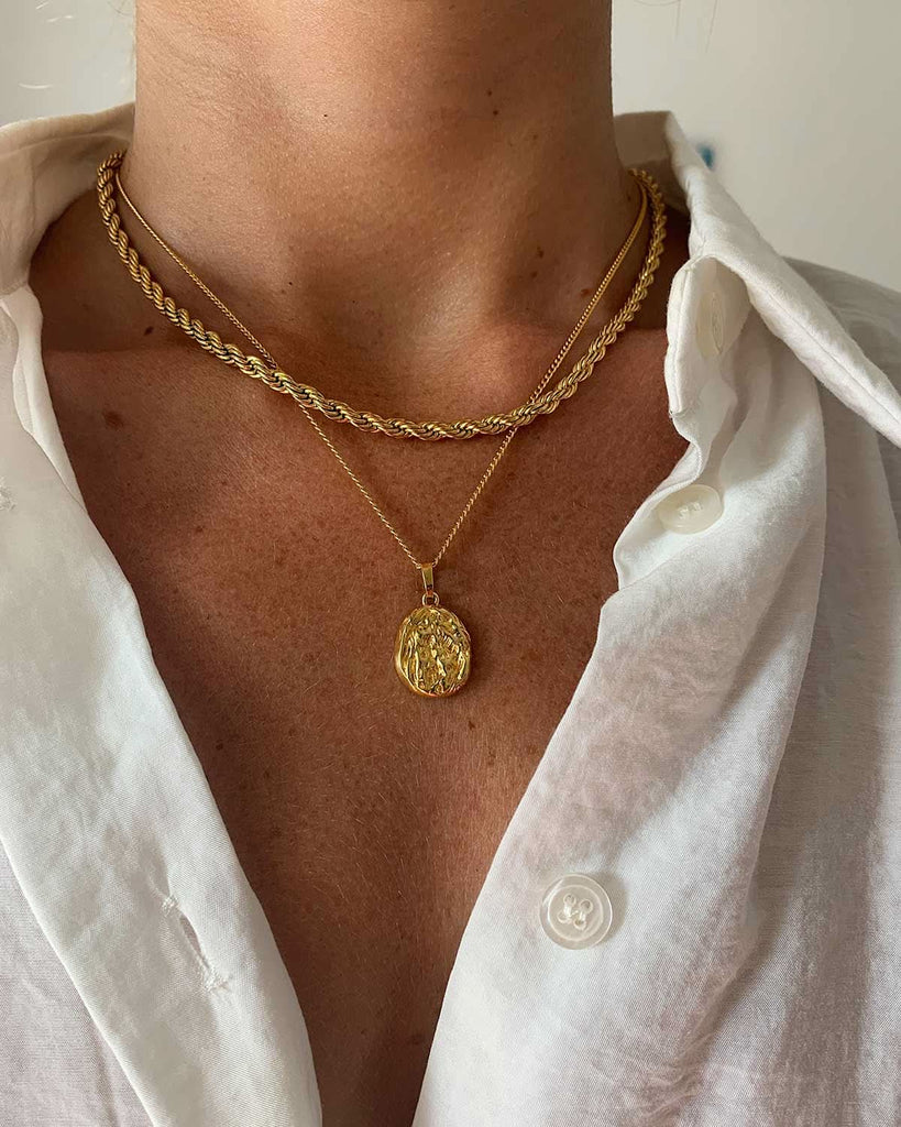 woman cleavage with two gold necklaces 