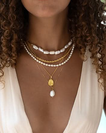 close up neck and cleavage with layers of necklaces 