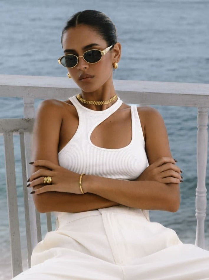 gold jewelry set styled with white top and wide leg trousers
